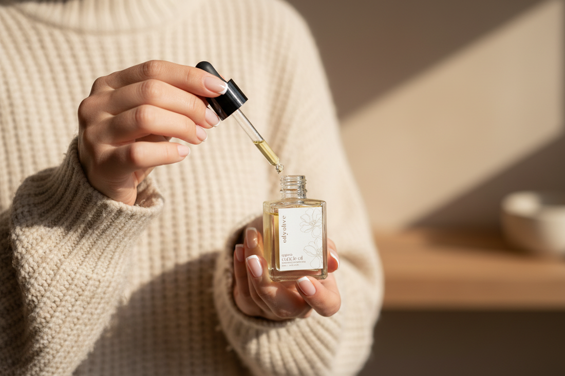 a lady holding oily olive's organic cuticle oil showing that it can be used on hands too not just cuticles. 